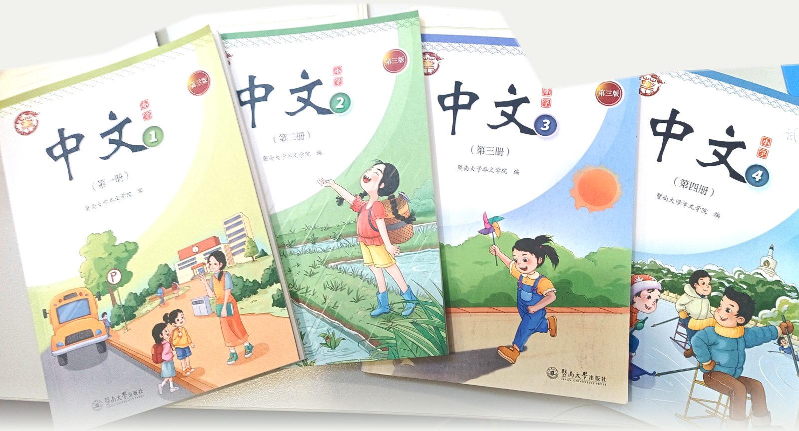 中文 Books 1–4, Jinan University Press, on a classroom table